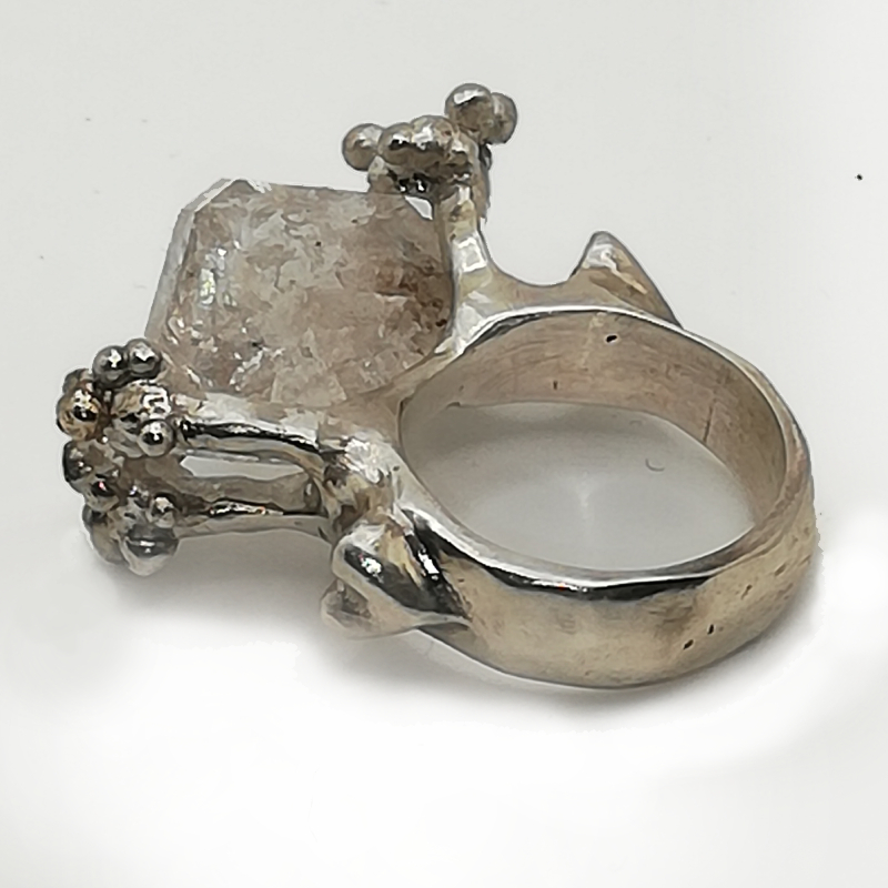 A statement silver ring with a large quartz rock held in place by silver antler buds. 