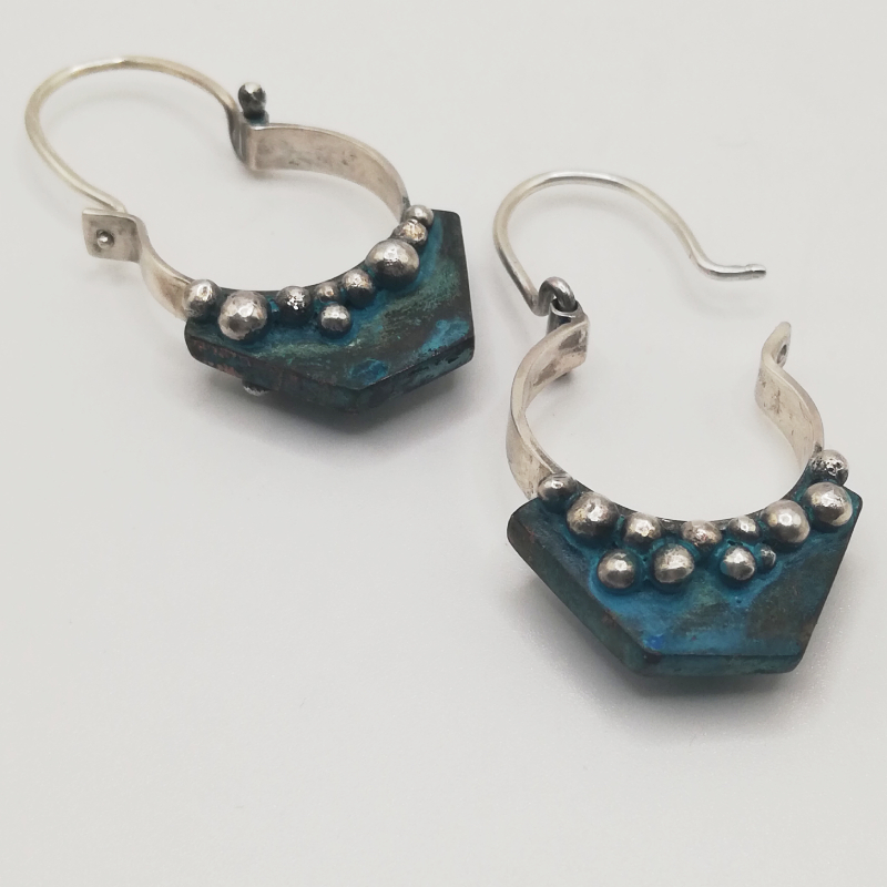 Two art deco style earrings with hinged posts, and an angular copper drop treated with Verdigris and surrounded with silver balls