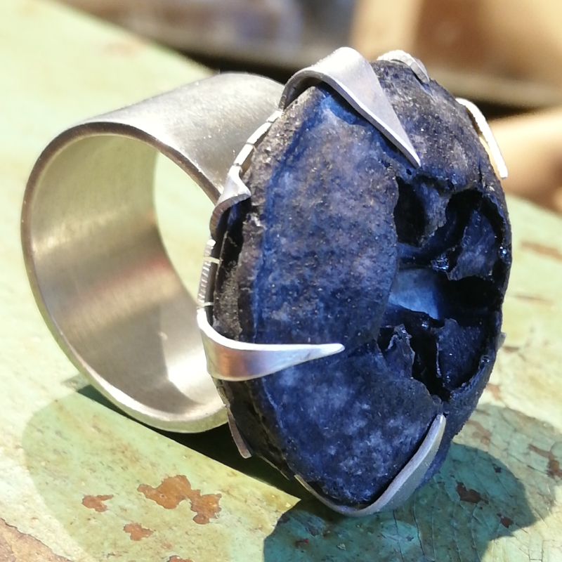 Chunky ring with concrete eucalyptus pod held by claws